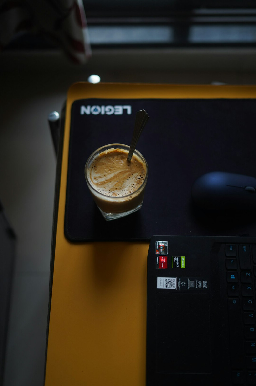 Laptop with code on a desk next to a coffee cup